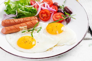 İngiliz kahvaltısı. Yağda yumurta, sosis, domates ve zeytin. Amerikan yemekleri..