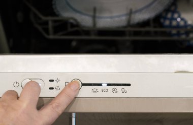 Enerji tasarrufu kavramı. Bulaşık makinesinin ekonomi modunu seçiyorum. Kaynakları kaydet