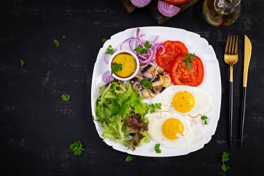 Ketojenik gıda. Yağda yumurta, mantar ve dilimlenmiş domates. Keto, paleo kahvaltısı. Üst görünüm, genel görünüm, kopyalama alanı