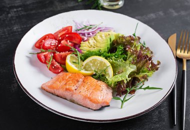 Ketogenik diyet kahvaltısı. Fırında somon salatası, yeşillik, domates, kırmızı soğan ve avokado. Keto, öğle yemeği..