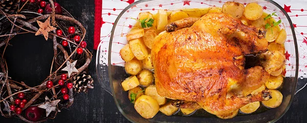 Baked turkey or chicken. The Christmas table is served with a turkey, decorated with bright tinsel. Fried chicken, table. Christmas dinner.  Top view, banner