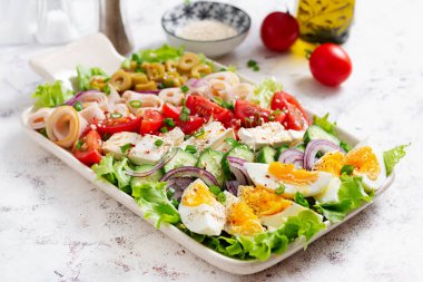 Healthy cobb salad with ham, cucumber, tomato, olives, feta cheese and eggs. Ketogenic lunch.