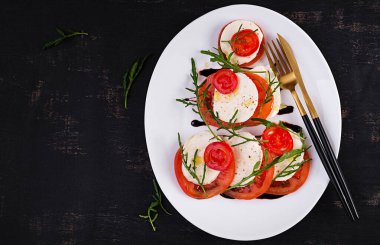 Salad Caprese with tomato, mozzarella and arugula in the shape of a Christmas tree. Top view, overhead