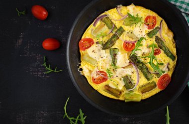 Healthy asparagus omelette. Eggs omelet with asparagus, tomatoes, and cheese. Top view, overhead