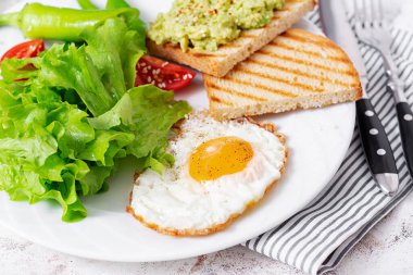 Fried egg, fresh salad and avocado guacamole sandwiches. Concept of a healthy lifestyle