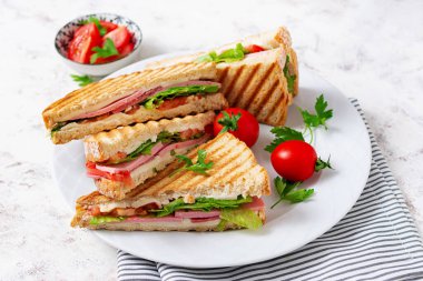 Club sandwich panini with ham, tomato, cheese and lettuce. Top view