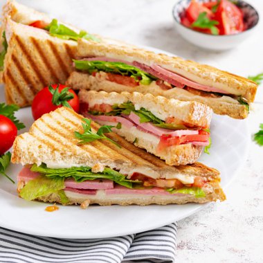 Club sandwich panini with ham, tomato, cheese and lettuce. Top view