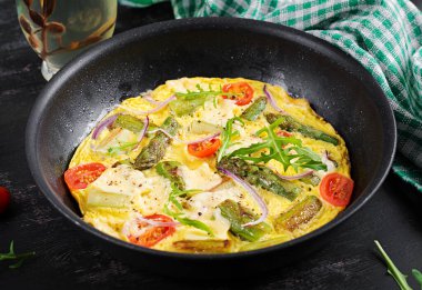 Healthy asparagus omelette. Eggs omelet with asparagus, tomatoes, and cheese.