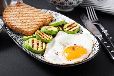 Breakfast. Toast with avocado guacamole, grilled zucchini and fried egg.  Brunch.