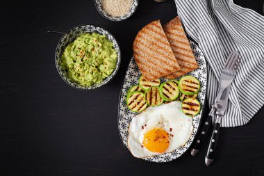 Breakfast. Toast with avocado guacamole, grilled zucchini and fried egg.  Brunch. Top view, flat lay