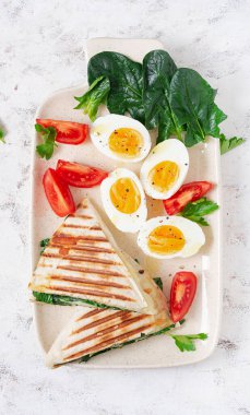 Fresh tortilla wraps with spinach and cheese on light background .  Healthy food concept. Vegetarian food. Top view, overhead