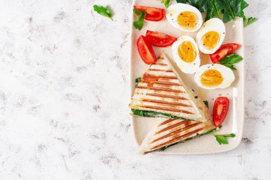 Fresh tortilla wraps with spinach and cheese on light background .  Healthy food concept. Vegetarian food. Top view, overhead