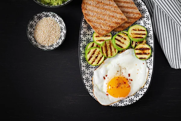 Breakfast. Toast with avocado guacamole, grilled zucchini and fried egg.  Brunch. Top view, flat lay