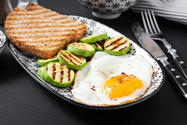 Breakfast. Toast with avocado guacamole, grilled zucchini and fried egg.  Brunch.