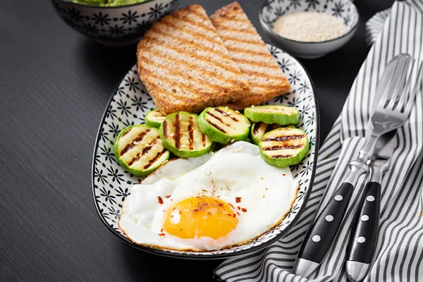 Breakfast. Toast with avocado guacamole, grilled zucchini and fried egg.  Brunch.