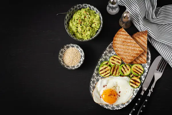 Breakfast. Toast with avocado guacamole, grilled zucchini and fried egg.  Brunch. Top view, flat lay