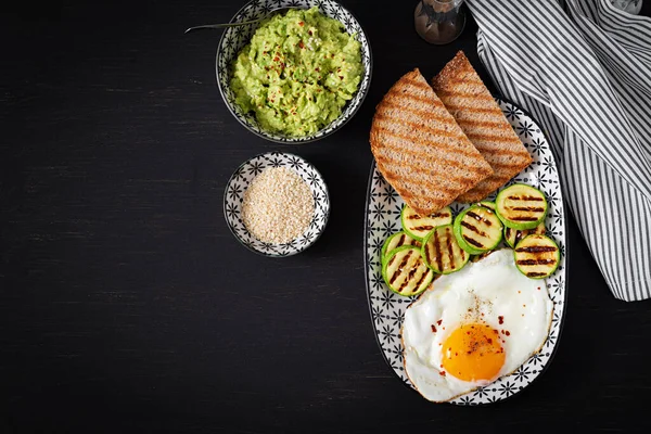 Breakfast. Toast with avocado guacamole, grilled zucchini and fried egg.  Brunch. Top view, flat lay