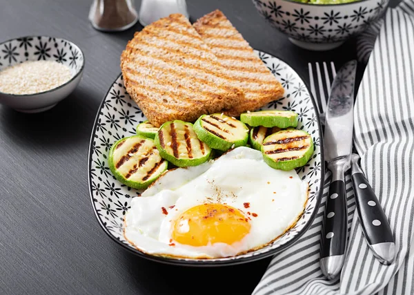 Breakfast. Toast with avocado guacamole, grilled zucchini and fried egg.  Brunch.