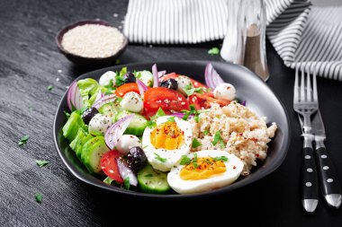 Healthy breakfast. Greek inspired savory oatmeal with fresh cucumber, tomatoes, olives, lettuce, mozzarella cheese and boiled egg. Top view