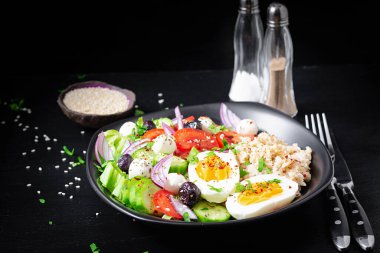 Healthy breakfast. Greek inspired savory oatmeal with fresh cucumber, tomatoes, olives, lettuce, mozzarella cheese and boiled egg. Top view