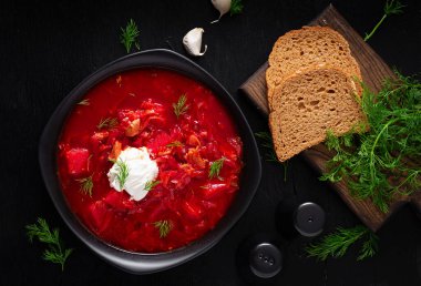 Traditional Ukrainian borscht. Bowl of red beetroot soup borsch with white cream. Beet root delicious soup. Ukrainian food. Top view, overhead
