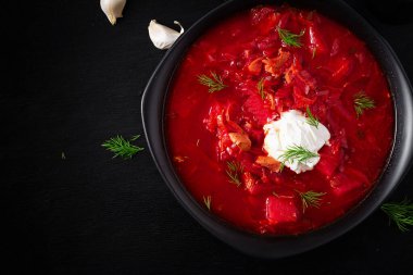 Traditional Ukrainian borscht. Bowl of red beetroot soup borsch with white cream. Beet root delicious soup. Ukrainian food. Top view, overhead