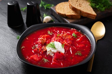 Traditional Ukrainian borscht. Bowl of red beetroot soup borsch with white cream. Beet root delicious soup. Ukrainian food.