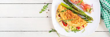 Ketojenik kahvaltı. Domatesli omlet, kırmızı soğan, somonlu sandviç ve kızarmış kuşkonmaz. İtalyan omleti. Keto, ketojenik öğle yemeği. Üst görünüm, afiş