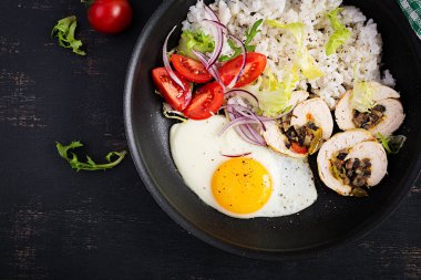 Kızarmış yumurta, etli tavuk, pilav ve domates. Paleo kahvaltısı. Üst görünüm, genel görünüm
