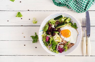 Kahvaltıda kızarmış yumurta, salatalık ve zeytinli yulaf lapası. Sağlıklı dengeli yiyecekler. Üst manzara, düz uzanma