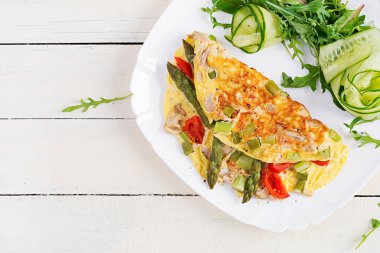 Keto kahvaltısı. Tavuk fileto, domates ve beyaz ahşap masada kuşkonmaz ile omlet. İtalyan omleti. Keto, ketojenik öğle yemeği. Üst görünüm, genel görünüm, kopyalama alanı