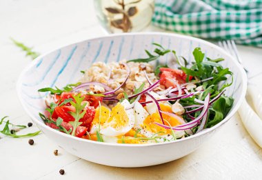 Kahvaltı yulaf lapası, haşlanmış yumurta, domates ve kırmızı soğan. Sağlıklı dengeli yiyecekler. Moda yiyecekler.