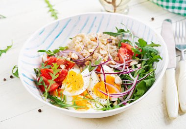 Kahvaltı yulaf lapası, haşlanmış yumurta, domates ve kırmızı soğan. Sağlıklı dengeli yiyecekler. Moda yiyecekler.