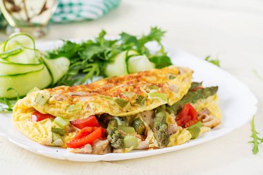 Keto kahvaltısı. Tavuk fileto, domates ve beyaz ahşap masada kuşkonmaz ile omlet. İtalyan omleti. Keto, ketojenik öğle yemeği..