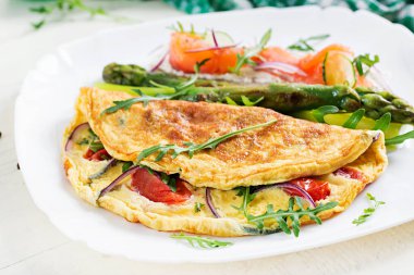 Ketojenik kahvaltı. Domatesli omlet, kırmızı soğan, somonlu sandviç ve kızarmış kuşkonmaz. İtalyan omleti. Keto, ketojenik öğle yemeği..