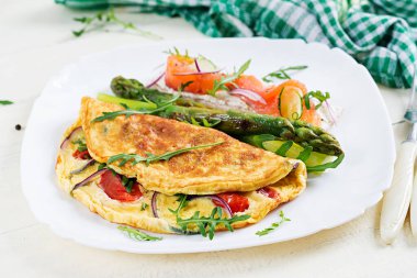 Ketojenik kahvaltı. Domatesli omlet, kırmızı soğan, somonlu sandviç ve kızarmış kuşkonmaz. İtalyan omleti. Keto, ketojenik öğle yemeği..