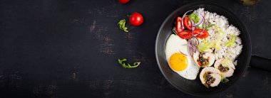 Kızarmış yumurta, etli tavuk, pilav ve domates. Paleo kahvaltısı. Üst görünüm, afiş