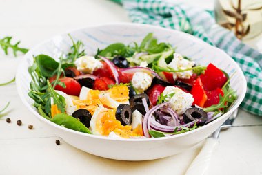 Kahvaltıda. Yunan salatası ve haşlanmış yumurta. Domates, salatalık, zeytin, roka ve krem peynirli taze sebze salatası. Moda yiyecekler.