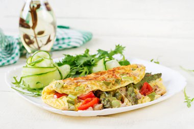 Keto kahvaltısı. Tavuk fileto, domates ve beyaz ahşap masada kuşkonmaz ile omlet. İtalyan omleti. Keto, ketojenik öğle yemeği..