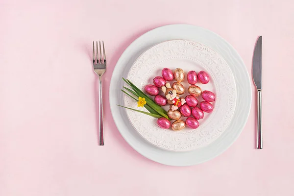 ハッピーイースター イースター休暇のテーブル設定 ピンクの背景にイースターエッグ ウサギ 花やカトラリー トップビュー フラットレイアウト — ストック写真