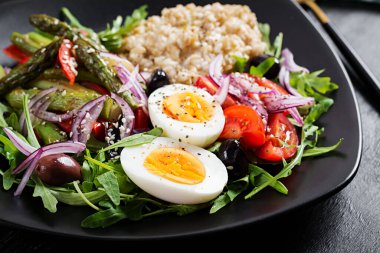 Kahvaltı yulaf lapası haşlanmış yumurta, vişneli domates, kuşkonmaz ve roka. Sağlıklı dengeli yiyecekler.