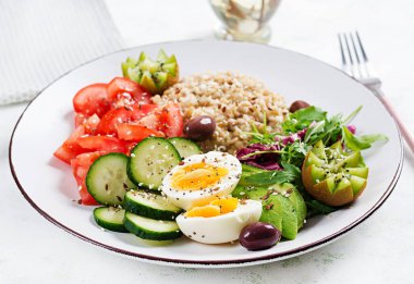 Kahvaltı yulaf lapası haşlanmış yumurta, taze salata ve kivi. Sağlıklı dengeli yiyecekler.