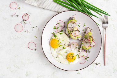 Sağlıklı kahvaltı için sahanda yumurta, avokado ve turplu sandviç. Üst manzara, düz uzanma