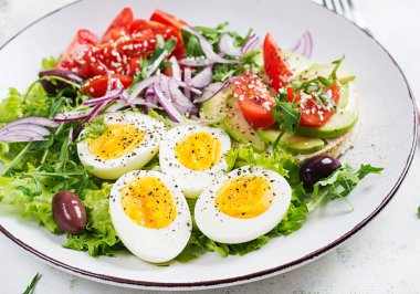 Domates, zeytin, haşlanmış yumurta ve peynirli sandviç ve avokado ile taze salata..