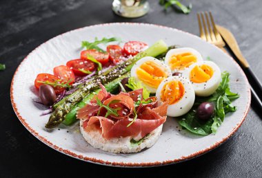 Keto kahvaltısı. Kızarmış kuşkonmaz, haşlanmış yumurta, jambonlu tost. Ketogenik diyet. Sağlıklı yemek..