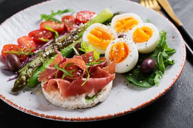 Keto kahvaltısı. Kızarmış kuşkonmaz, haşlanmış yumurta, jambonlu tost. Ketogenik diyet. Sağlıklı yemek..