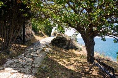 Bulgaristan. Güneşli bir yaz gününde Cape Kaliakra 'daki kayalıkların ve ortaçağ kalelerinin yakınlarındaki taş patikalarında deniz ve mavi gökyüzü arka planda..