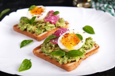 Avokado püresi, haşlanmış yumurta, baharat ve kırmızı soğanlı sağlıklı tost. Lezzetli kahvaltı ya da atıştırmalık.
