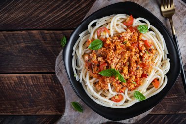 Spagetti makarna ve domates sosu ve ahşap arka planda tavuk kıyması. Makarna bolonez. Üst görünüm