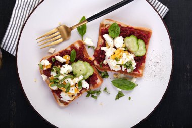 Pate pancar, haşlanmış yumurta, fesleğen ve salatalıklı sağlıklı tost. Lezzetli kahvaltı ya da atıştırmalık. Üst görünüm